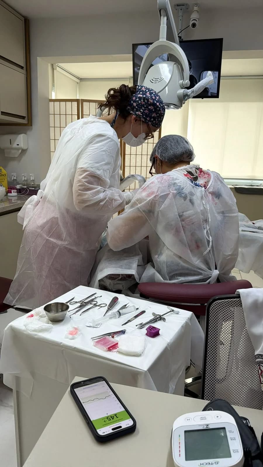 Equipe realizando atendimento odontológico cuidadoso a uma paciente