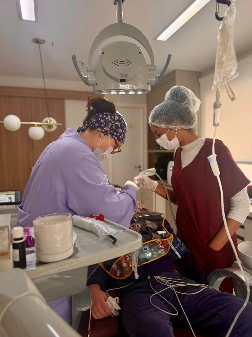 Equipe odontológica realizando atendimento de paciente com deficiência sob sedação